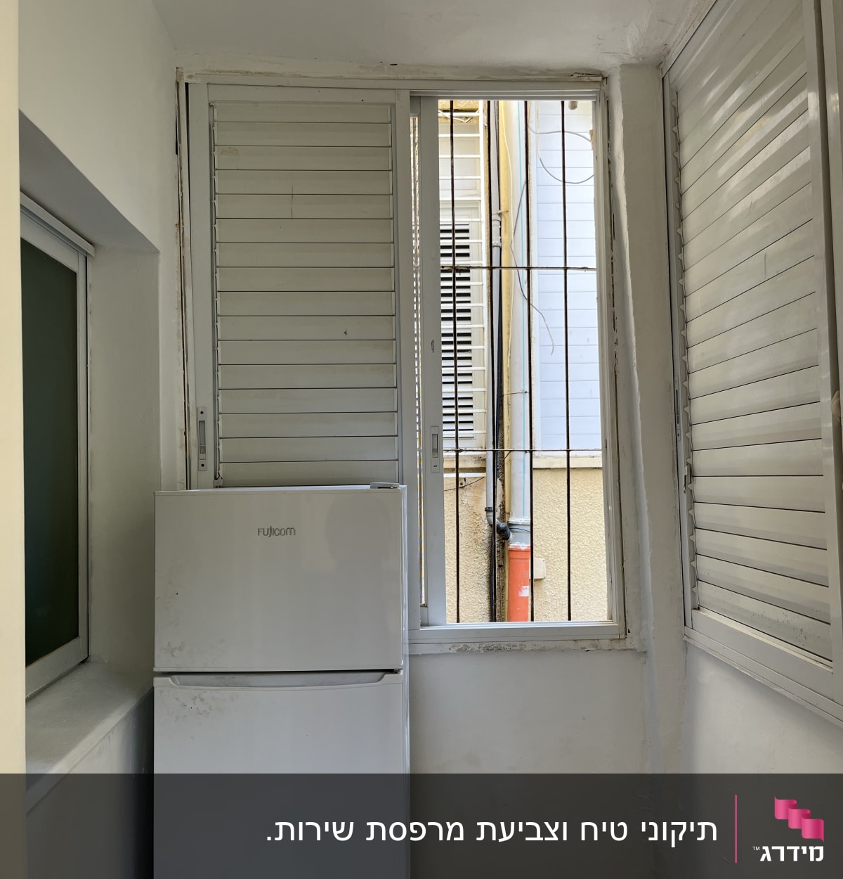 מקרר לבן ליד חלון עם תריסים